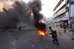 A man sets fire to some substances at Satmatha intersection in Bogra town Sunday morning. Nine people were killed during series of clashes in the district. Photo: STAR 