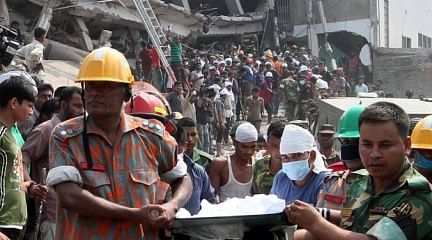 In this April 25 photo, rescuers are seen bringing a body recovered from debris of the collapsed building in Savar on the outskirts of the capital.