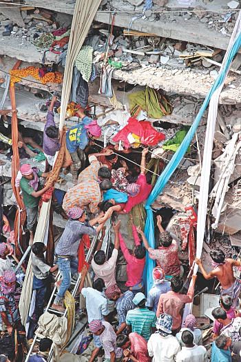 Firemen with the help of a large number of local volunteers rescue garment workers from the sandwiched floors of Rana Plaza at Savar Bazar bus stand after it collapsed yesterday morning. Photo: Palash Khan