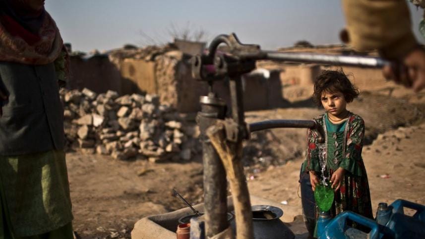 Afghan regugees pumps water.jpg
