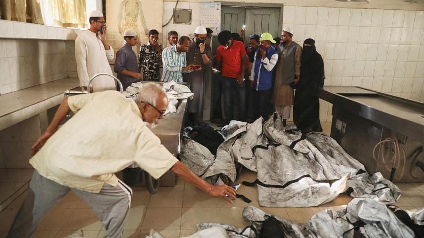 Relatives of victims of a fire incident attempt to identify the bodies at Dhaka Medical College Hospital
