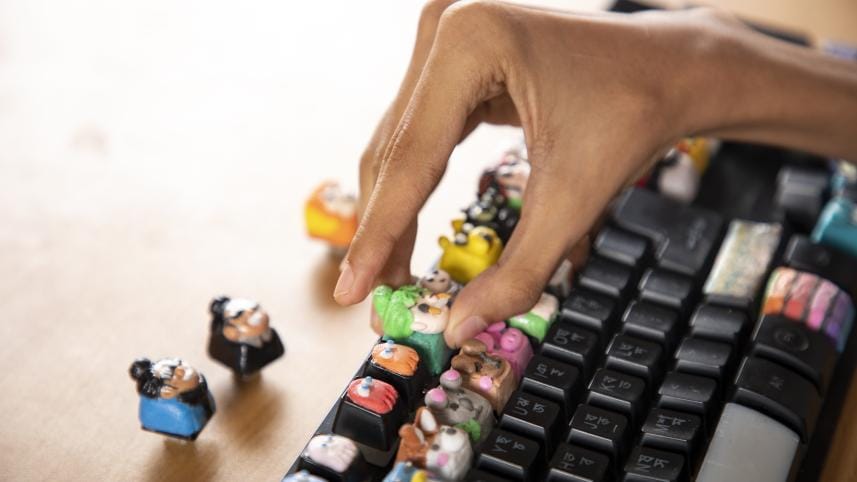 Custom made keycaps being placed on the keyboard. 
