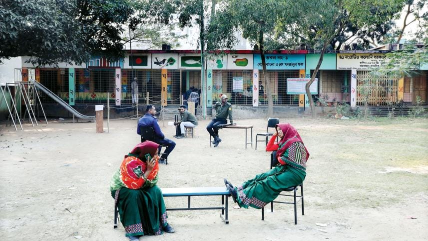 Two female poll clerks were engaged in chitchat while, right behind them, an Ansar man and police official were lounging at Savar’s Radio Colony School and College polling centre due to a lack of voters yesterday. The photo was taken at 2:30pm, an hour an