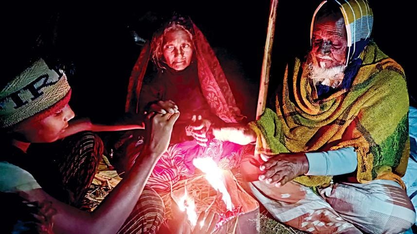 An elderly couple and their grandchild try to fend off the cold by burning straws outside their home in Kutir Chandrakhana area of Kurigram’s Phulbari upazila last night. With the mercury dropping below 10 degrees Celsius, people struggle to work outside 