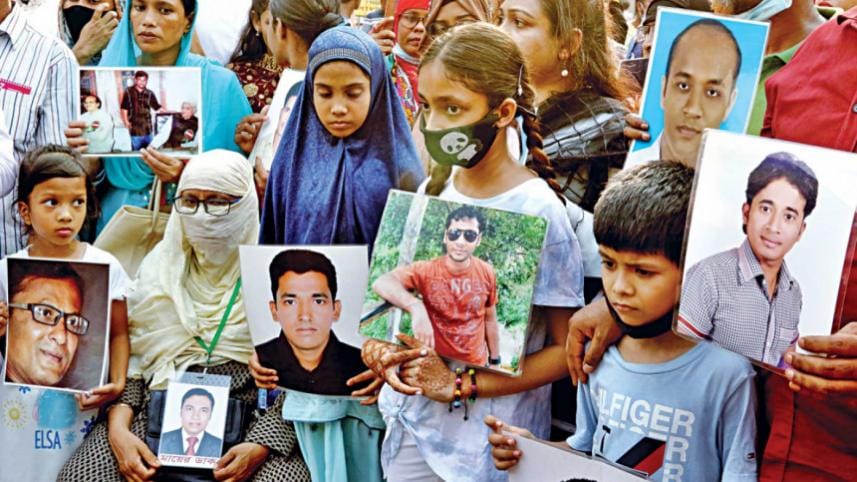 Bangladesh enforced disappearances: Children of the victims of enforced disappearances hold their photos at a rally in front of the National Museum in Dhaka