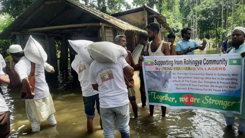 Rohingyas stand beside flood affected people.jpg