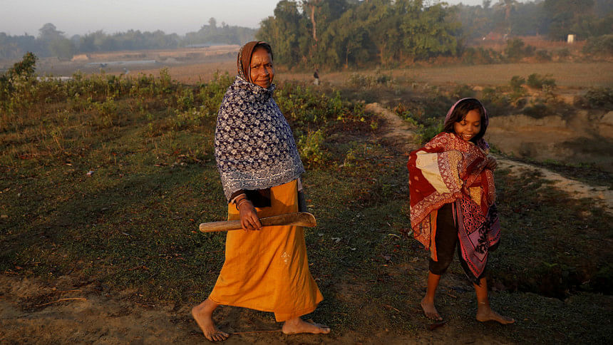 Rohingya refugee walks with her daughter Rohingya refugee walks with her daughter