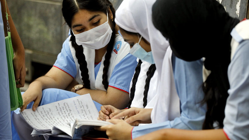 A photo of girls sitting together and reading a textbook A photo of girls sitting together and reading a textbook