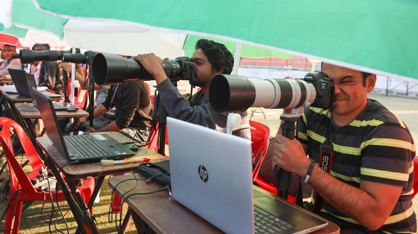 Journalists covering a sports event by taking pictures.