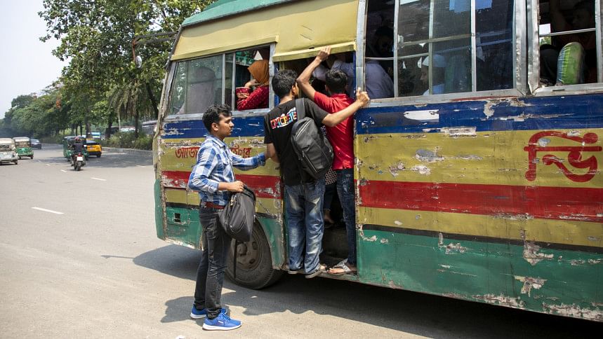 Student trying to get on a crowded bus.