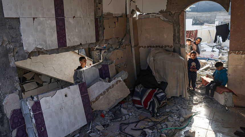 Palestinian youths are seen in the rubble of a damaged house in Rafah in the southern Gaza Strip