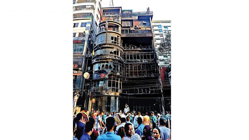 Death came draped in smoke onlookers gather in front of the charred seven-storey building.