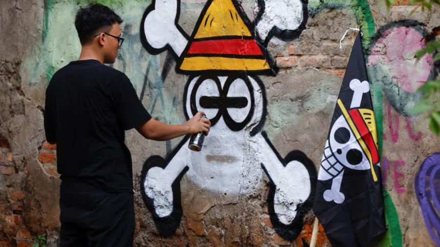 Kemas Muhammad Firdaus, 28, paints a mural depicting a Jolly Roger from the popular Japanese anime and manga series 'One Piece' in Bekasi, West Java province, Indonesia, August 7, 2025.