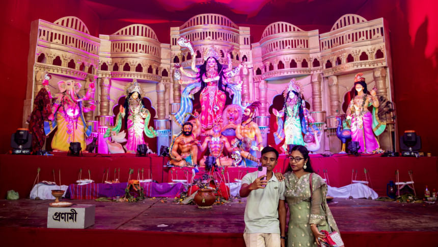 Two people taking a selfie in front of the idol