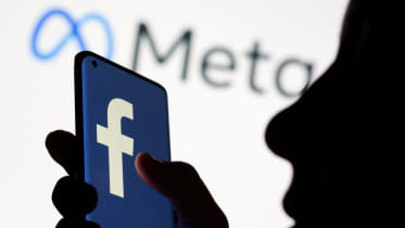 Woman holds smartphone with Facebook logo in front of a displayed logo for Meta in this illustration picture taken October 28, 2021. Photo: Reuters