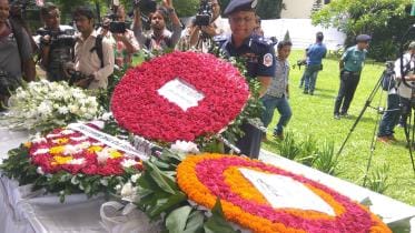 Law enforcers along with friends and family members pay homage to the victims of the Holey Artisan attack