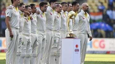Australia's cricketers stand during national anthem