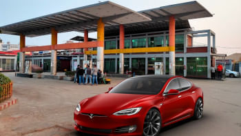 A Tesla going past a fuel pump