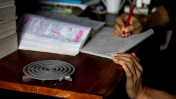 Student in their dorm room with a mosquito repellent coil burning.