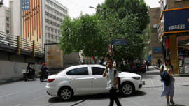 People walk near an anti-US mural on a building in Tehran, Iran, May 19, 2026. Photo: Reuters