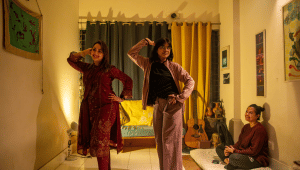 three friends at a holud rehearsal