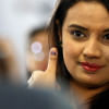 A woman flashes the ink on her thumb A woman flashes the ink on her thumb