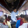 An exhausted person standing in the aisle of a bus.
