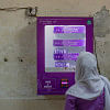 Woman collecting a sanitary pad from a vending machine.