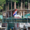 A flag of one of the Myanmar rebel forces is installed next to an under-construction structure in Myanmar's Khawmawi village on the India-Myanmar border in Mizoram