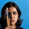 Portrait of an artist holding up drawing and painting utensils against her face. Portrait of an artist holding up drawing and painting utensils against her face.
