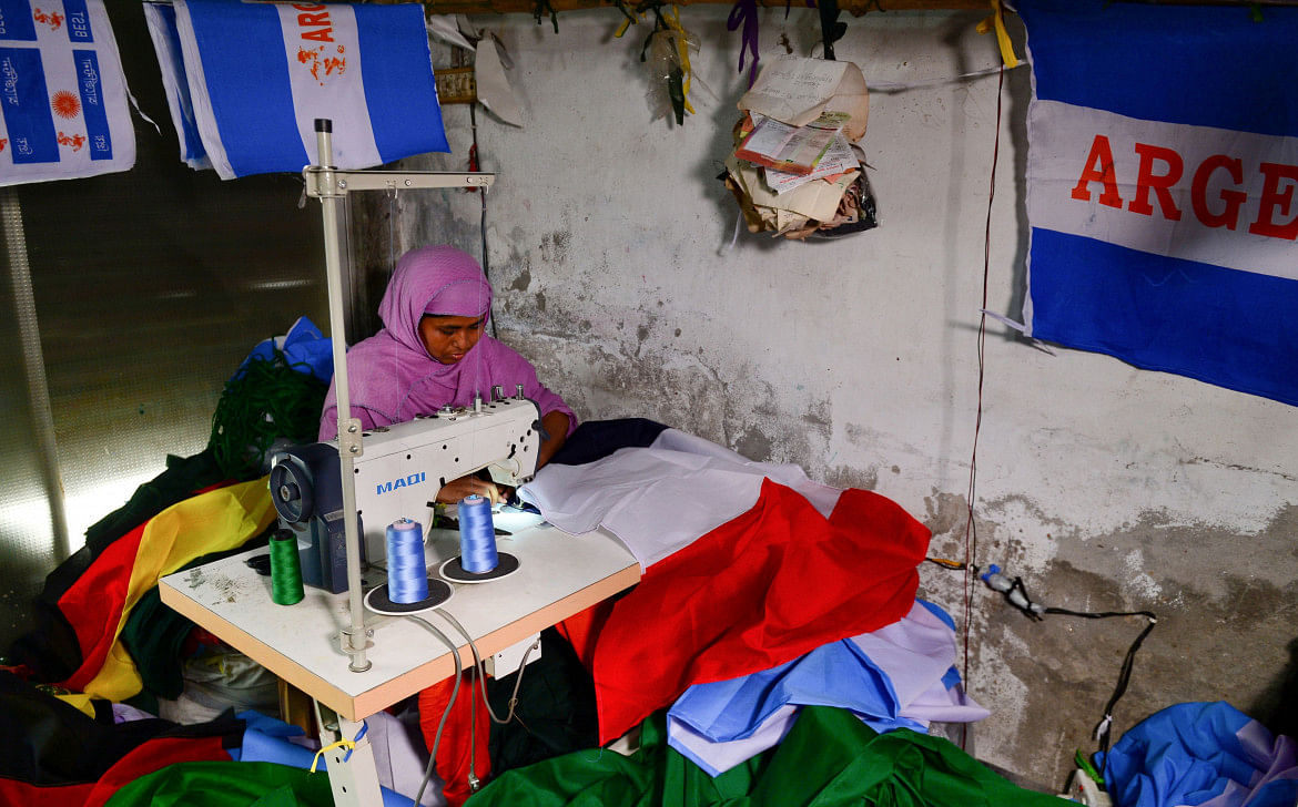 Bangladeshi worker sewing an Egypt flag in Narayanganj, 