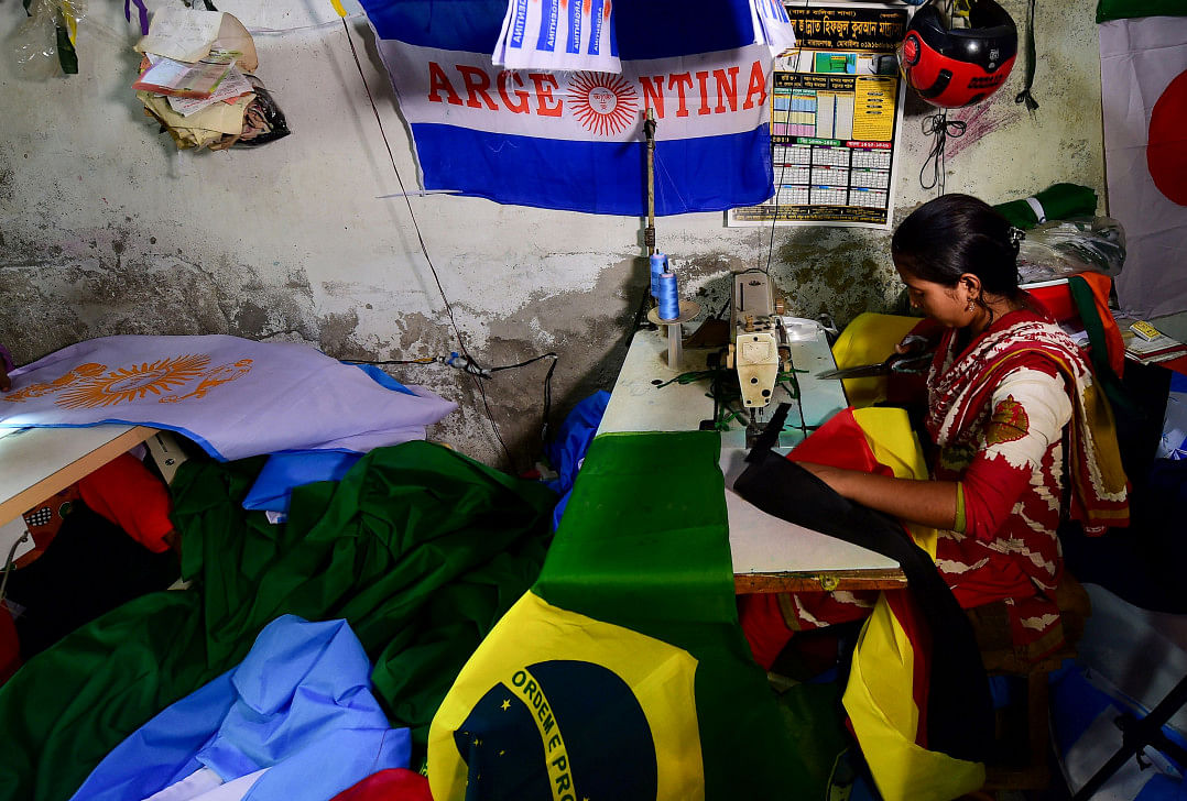 Bangladeshi worker sewing flags for world cup football playing nations in Narayangan