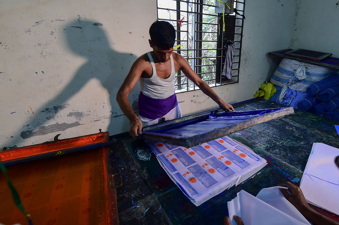 Bangladeshi worker using a silk-screen for printing Argentina flags in Narayanganj