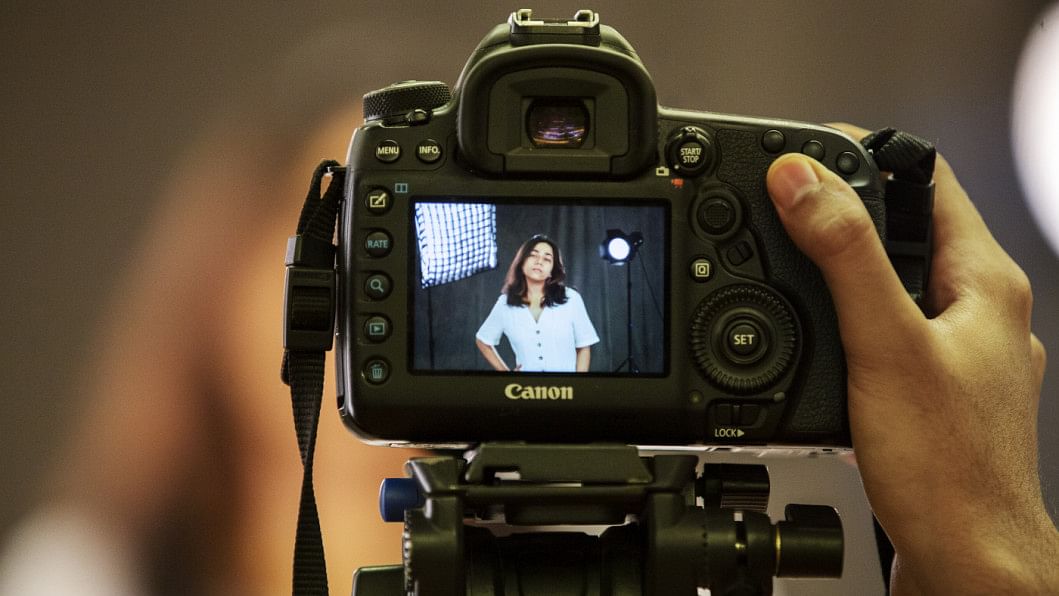 Model seen posing through the camera.