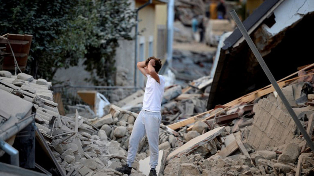 A man stands among damaged buildings Italy, earthquake, rubble, disaster