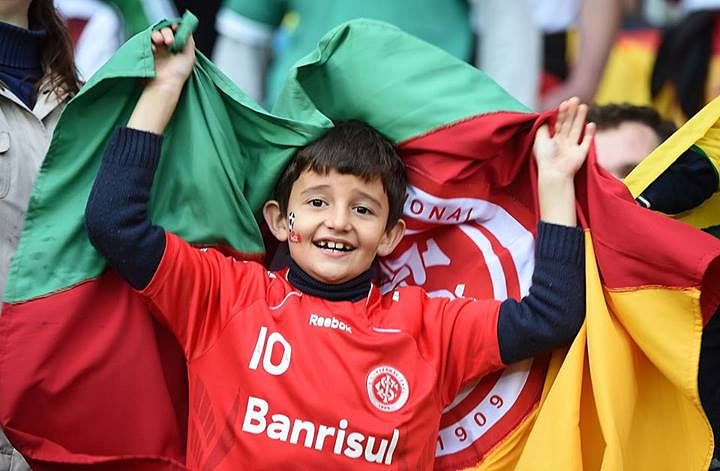 A young Algerian fan cheers before a Round of 16 football match between Germany and Algeria at Beira-Rio Stadium in Porto Alegre during the 2014 FIFA World Cup. Photo: Getty Images.