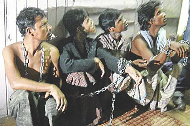 Four Myanmarese are seen chained together in a room. Malaysian police rescued them along with 11 Bangladeshis on Thursday. They had apparently fallen victim to an illegal immigrant-trafficking syndicate. Photo: The Star (Malaysia) 