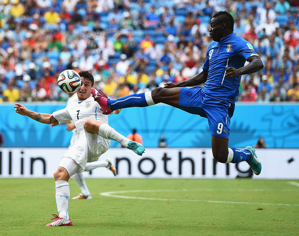 Mario Balotelli of Italy and Cristian Rodriguez of Uruguay compete for the ball during the 2014 FIFA World Cup Brazil Group D match between Italy and Uruguay at Estadio das Dunas on June 24, 2014 in Natal, Brazil. Photo: Getty Images