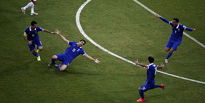 Greece defender Sokratis Papastathopoulos celebrates celebrates with teammates after scoring his team's equaliser during their round of 16 match against Costa Rica in Recife on June 29, 2014. Photo: Getty Images