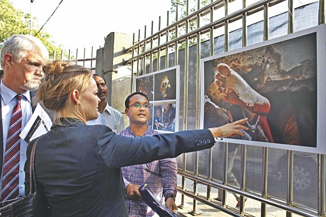 William Hanna, ambassador of EU delegation, and Denmark's envoy Hanne Fugl Eskjaer looking at a photo taken by The Daily Star's Rashed Shumon during an exhibition titled 