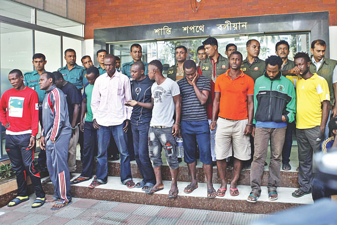 A section of 31 foreign nationals, who were arrested by the Detective Branch of Dhaka Metropolitan Police in the capital yesterday on the charge of living in the country illegally. They were produced before the media at DB office. Such foreign nationals have been involved in different criminal activities, including killing and drug peddling, for a long time, a DMP press release said.  Photo: Star