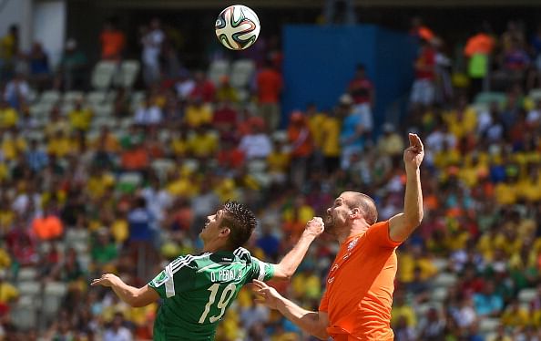 Mexico's forward Oribe Peralta (L) challenges Netherlands' defender Ron Vlaar for the ball during a Round of 16 football match between Netherlands and Mexico at Castelao Stadium in Fortaleza during the 2014 FIFA World Cup on June 29, 2014. Photo: Getty Images 