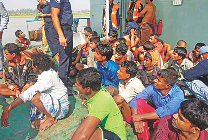 A number of the surviving fortune seekers on a coast guard boat heading for the shore yesterday. The fortune seekers were going to Malaysia illegally on a boat when it sank near Kutubdia. Photo: Star