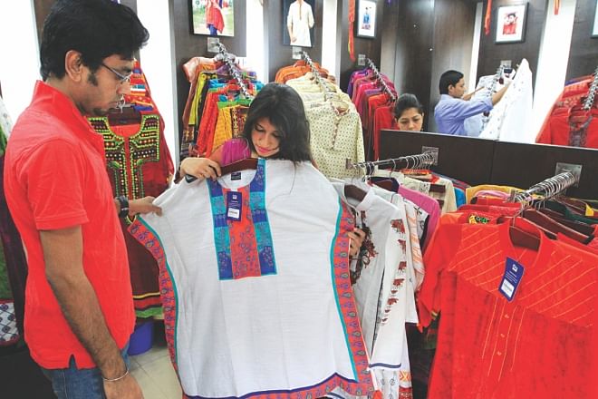 A customer checks a dress at a shop in Dhaka yesterday. Photo: STAR
