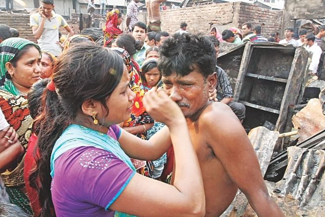 A daughter tries to console her father, who lost his home in a fire that broke out at a slum In Mirpur-2. Photo: Amran Hossain/Courtesy 