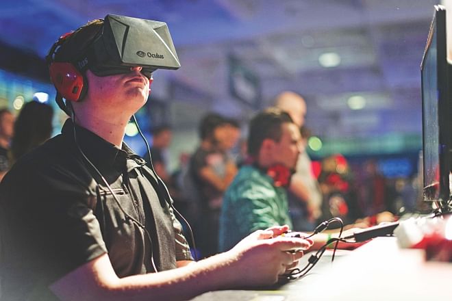 A gaming enthusiast uses an Oculus virtual reality headset at the Eurogamer Expo 2013 in London last year. Facebook on Tuesday announced a $2-billion deal to buy a startup behind virtual reality headgear that promises to let people truly dive into their friends' lives.  Photo: AFP/File