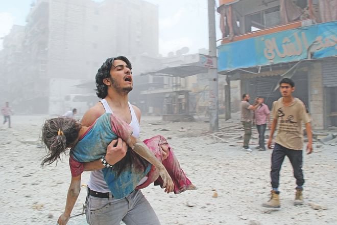 A man carries a young girl who was injured in a reported barrel-bomb attack by government forces in Aleppo, yesterday.  Photo: AFP