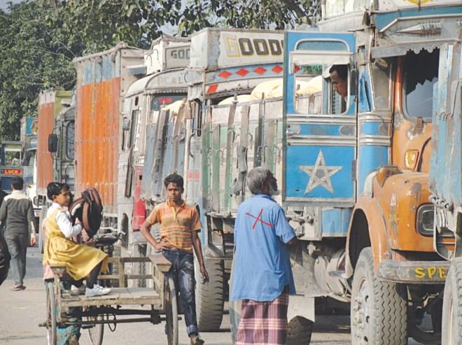 A man (marked X), engaged by the leader of a so-called labourers' association, demands illegal toll from an Indian truck driver at Burimari land port a couple of days ago.   PHOTO: STAR