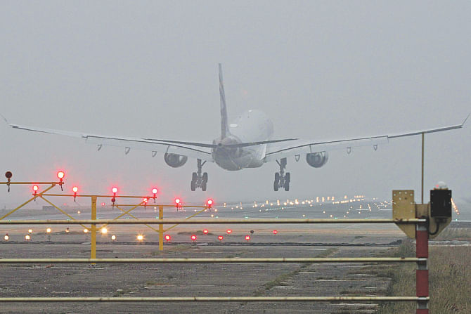 A plane lands in Dhaka in the foggy morning yesterday as a cold spell grips the capital. Photo: Anisur Rahman\Star
