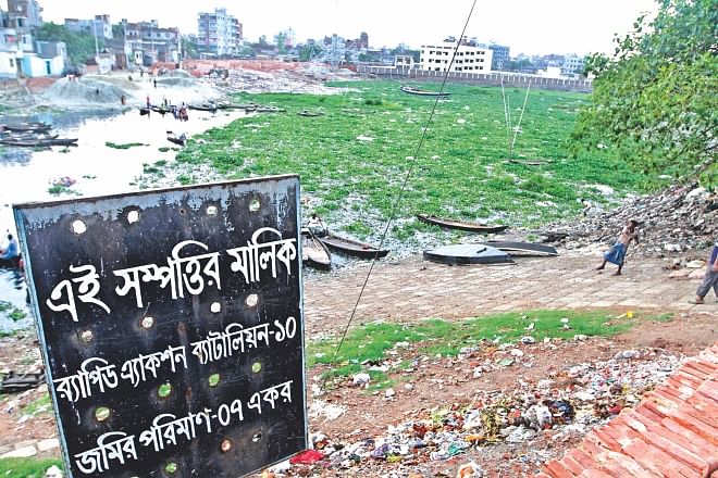 A sign at Sharifnagar of Kamrangirchar in the capital claiming that the seven acre “land” belongs to Rab-10, which in reality is a channel of the Buriganga. The government yesterday finally cancelled the allocation. Photo: Amran Hossain